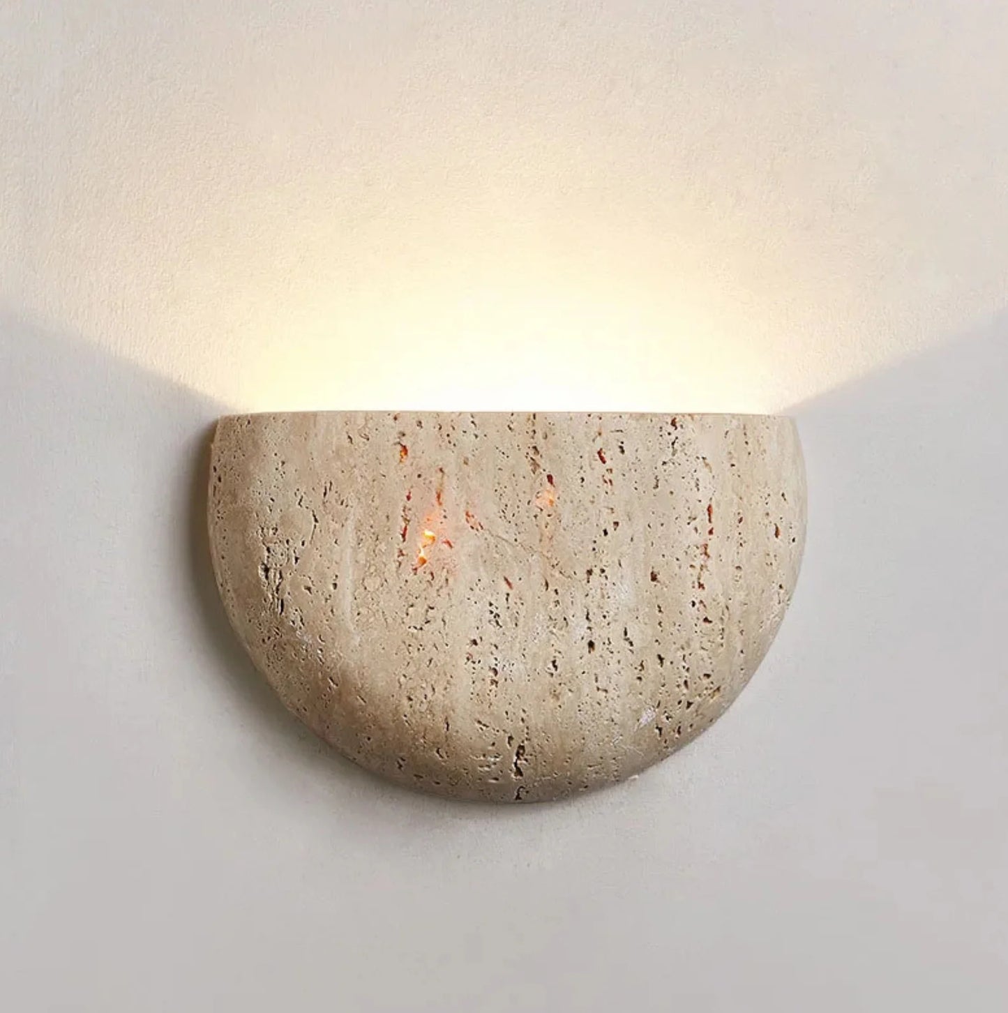 Stone wall sconce with a warm glow on a white background