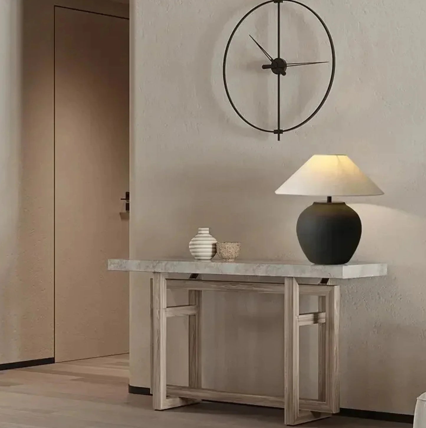 Console table with decorative items and a lamp against a neutral wall with a clock.