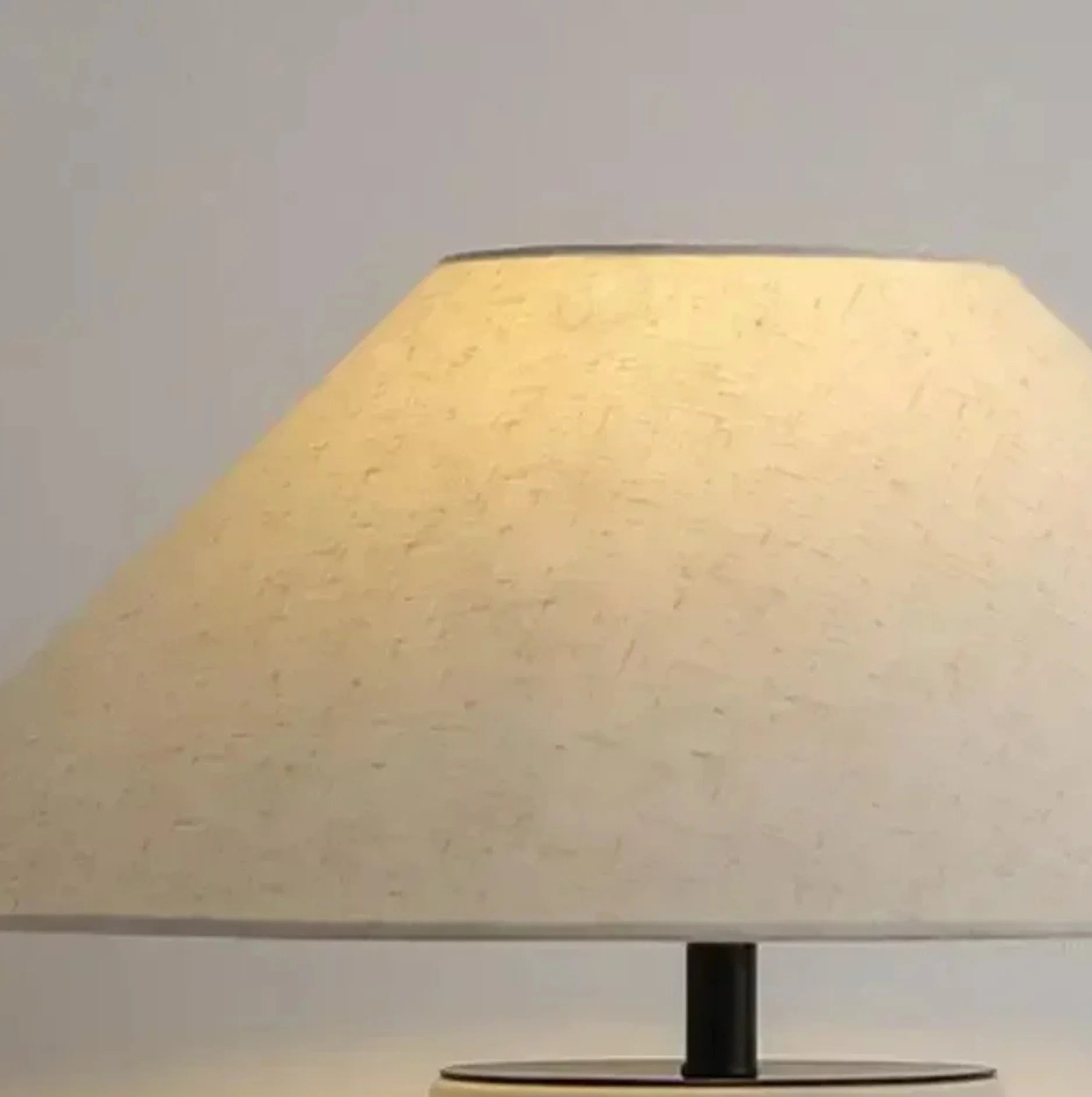 Table lamp with a beige shade on a plain background