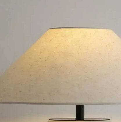Table lamp with a beige shade on a plain background
