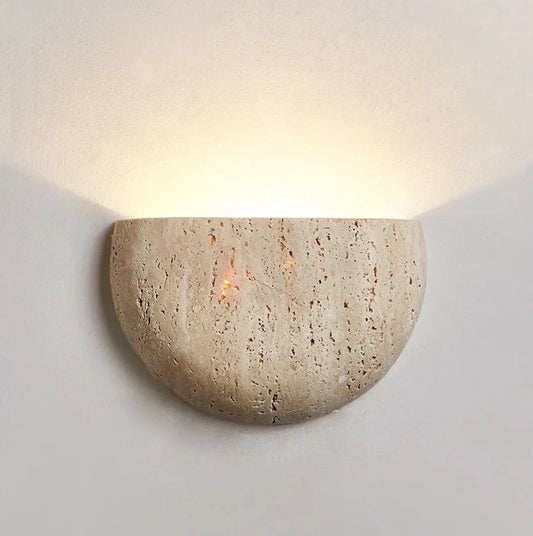 Stone wall sconce with a warm glow on a white background