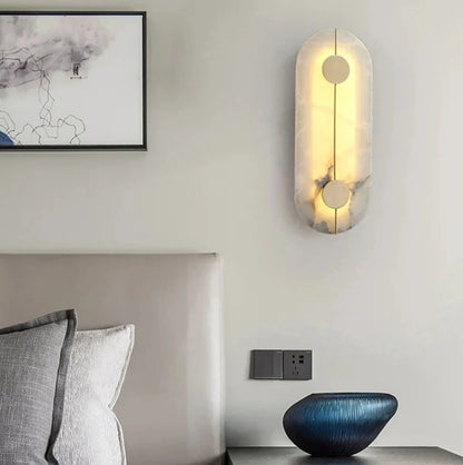Modern wall sconce in a bedroom setting with a bed and decorative bowl.