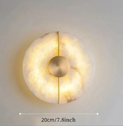 Decorative wall light with marble-like texture and gold accent on a neutral background