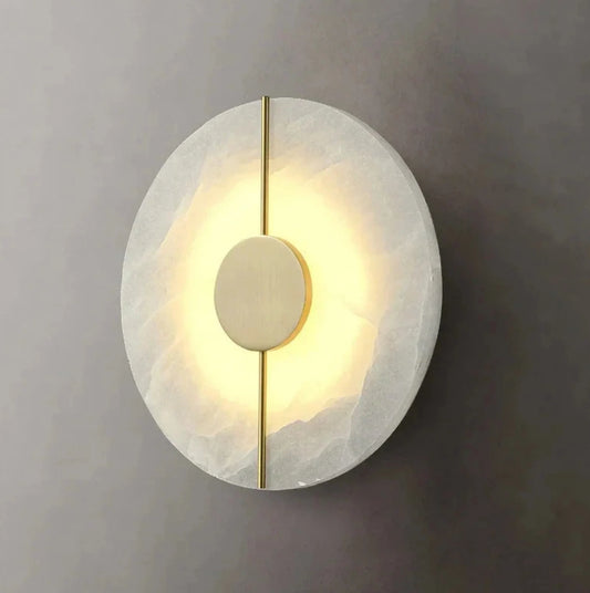 Round wall light fixture with marble texture and gold accent on a gray wall.