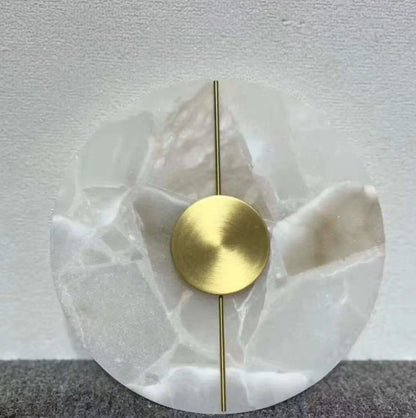 Decorative wall piece with gold circular element and white marbled base