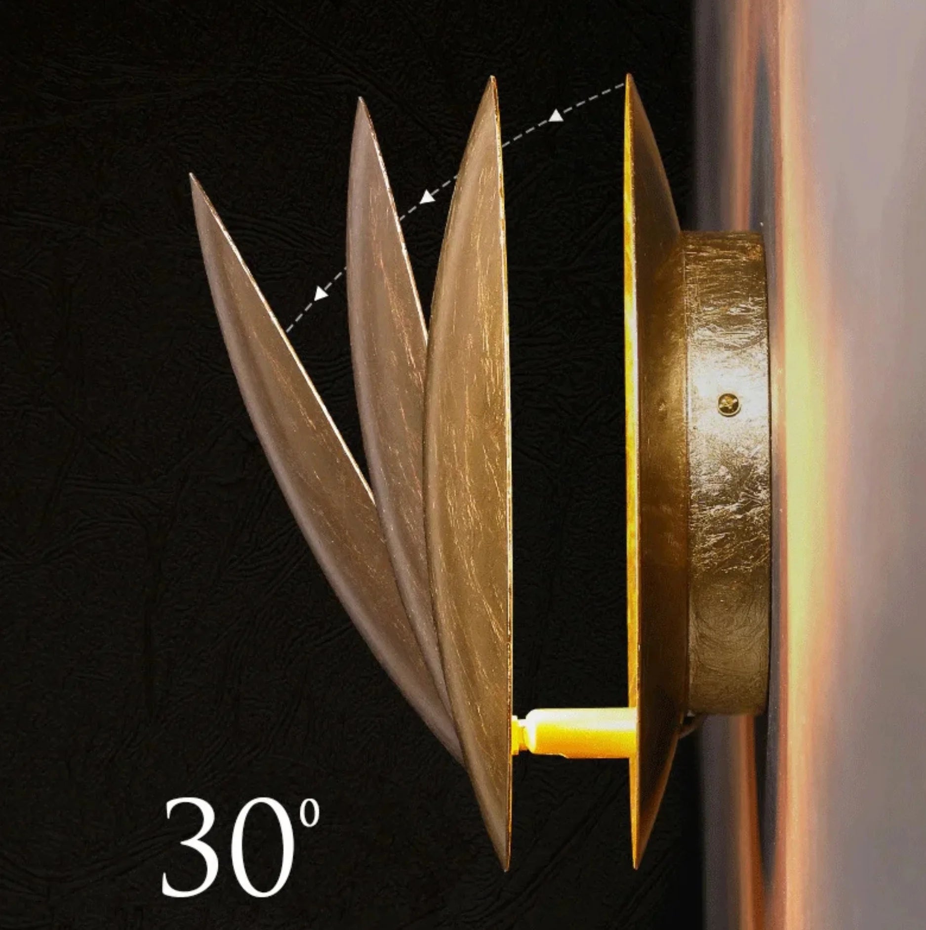 Decorative wall light fixture with metallic finish on a dark background