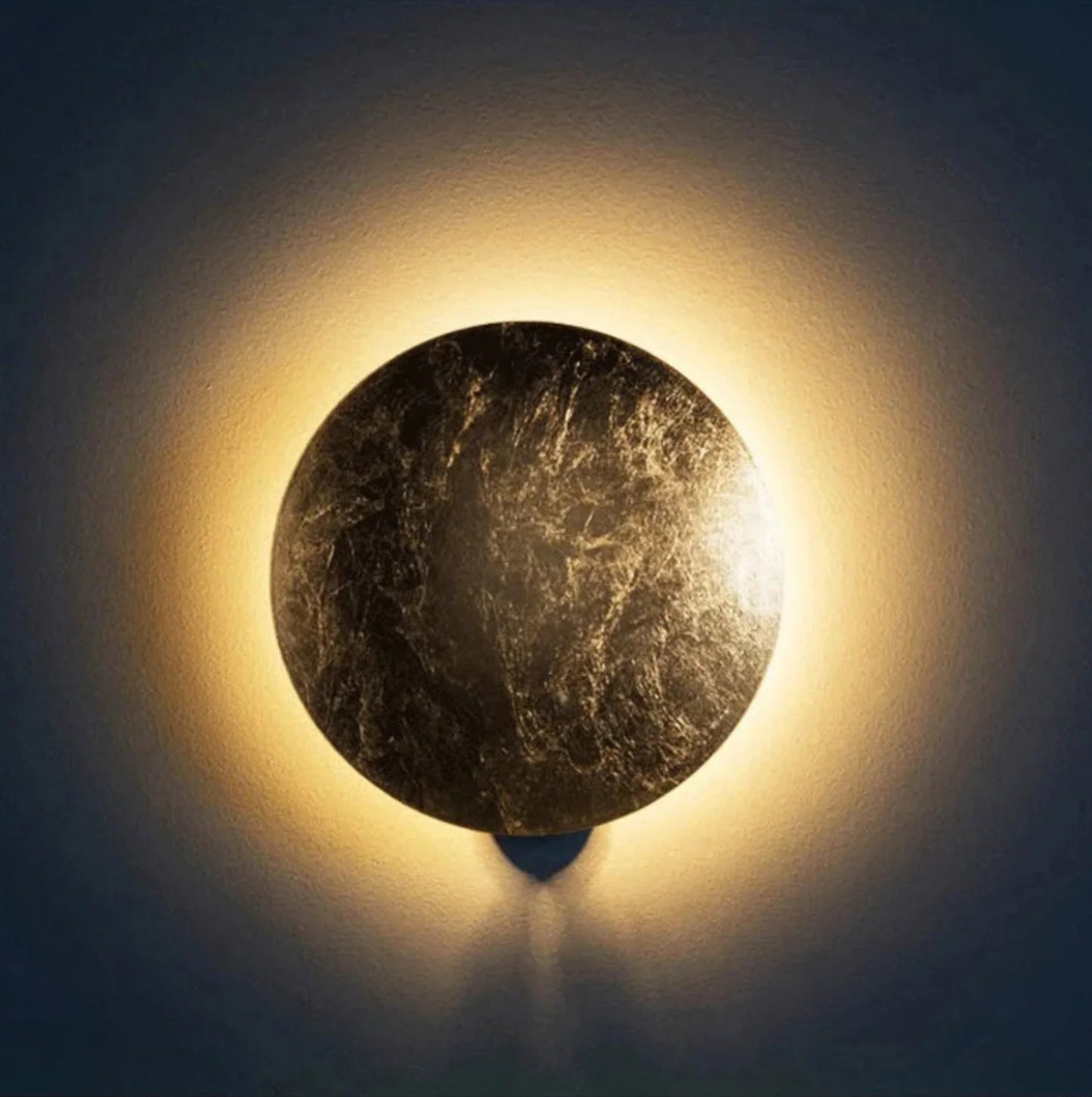 Round stone wall light fixture emitting a warm glow against a dark background